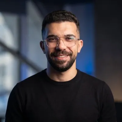 Hady Ashraf, smiling, in a black sweater